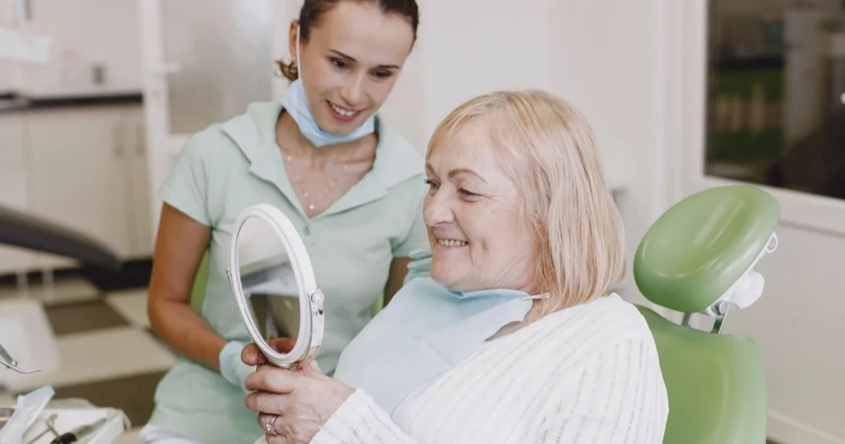 An older woman checking her teeth and smiling
