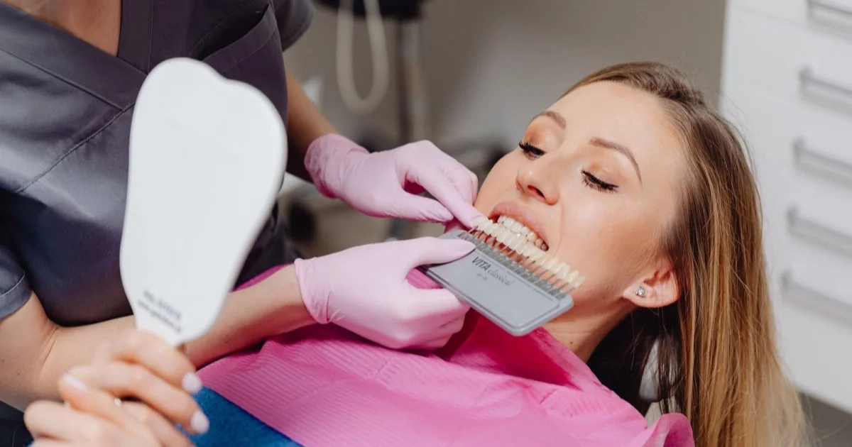 Dentist selecting tooth colour with a shade guide