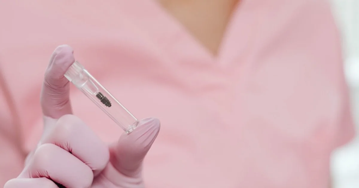 Close-up of a dental implant held in a hand