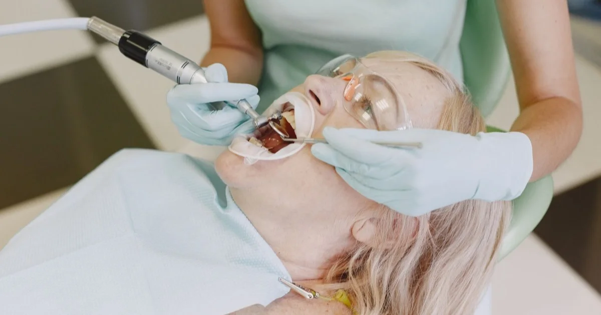 A dentist checking a patient's teeth with a mirror