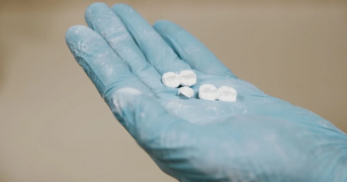 White zirconia prosthesis held in a gloved hand