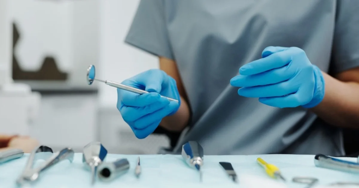 A surgeon's gloved hands and instruments